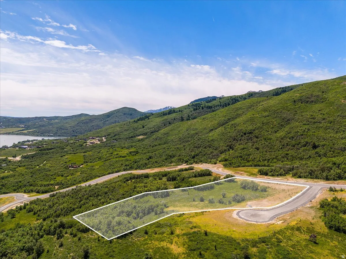 Aerial view of property and surrounding area featuring property boundaries highlighted and a water and mountain view