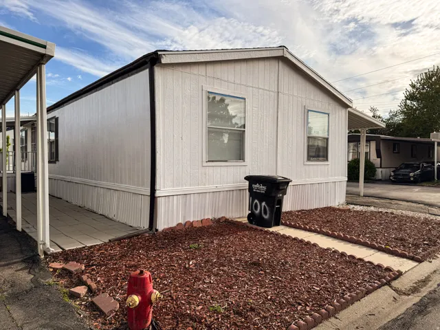 White manufactured home featuring a gabled roofline