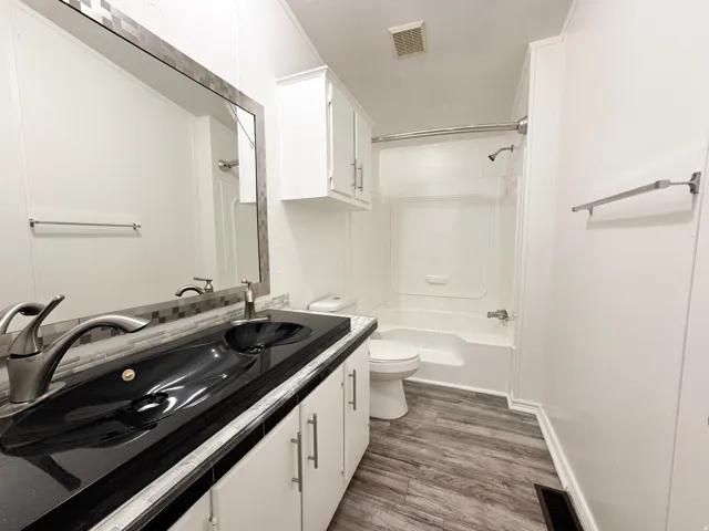 Double vanity featuring black sinks and a dark countertop