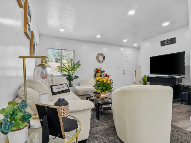 Living area featuring recessed lighting, a white paneled interior door, and a window providing natural light