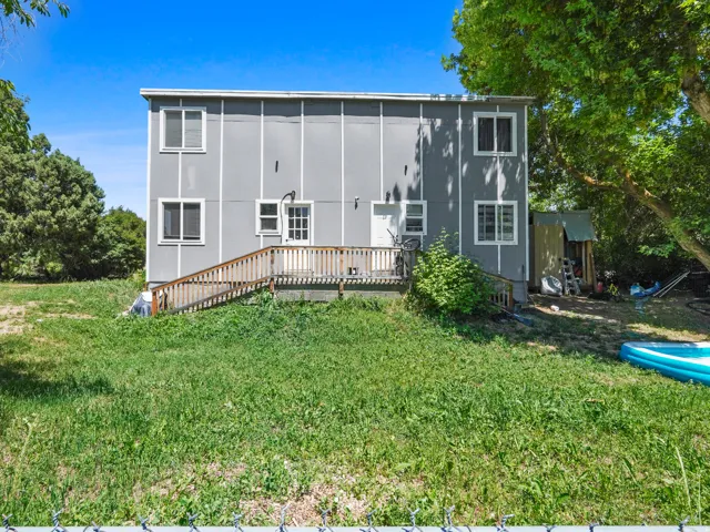 Two-story exterior with light gray siding and white trim windows