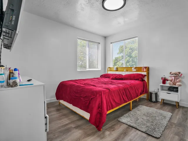 Room featuring multiple windows, wood-finish flooring, a contemporary flush-mount ceiling light, and white painted walls