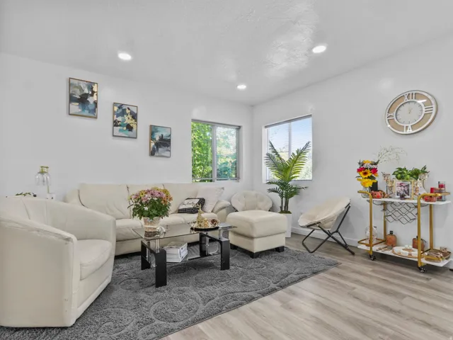 Bright living space featuring wood-finish flooring, recessed lighting, and white walls