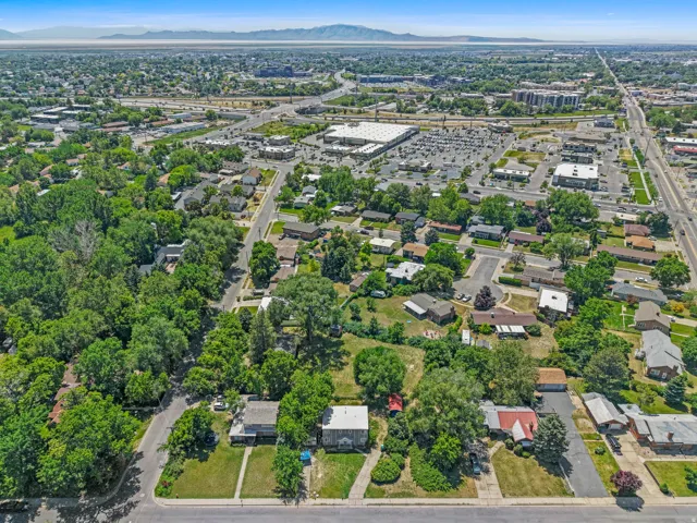 Aerial view of a residential neighborhood with established trees, paved streets, and a mix of single-story homes