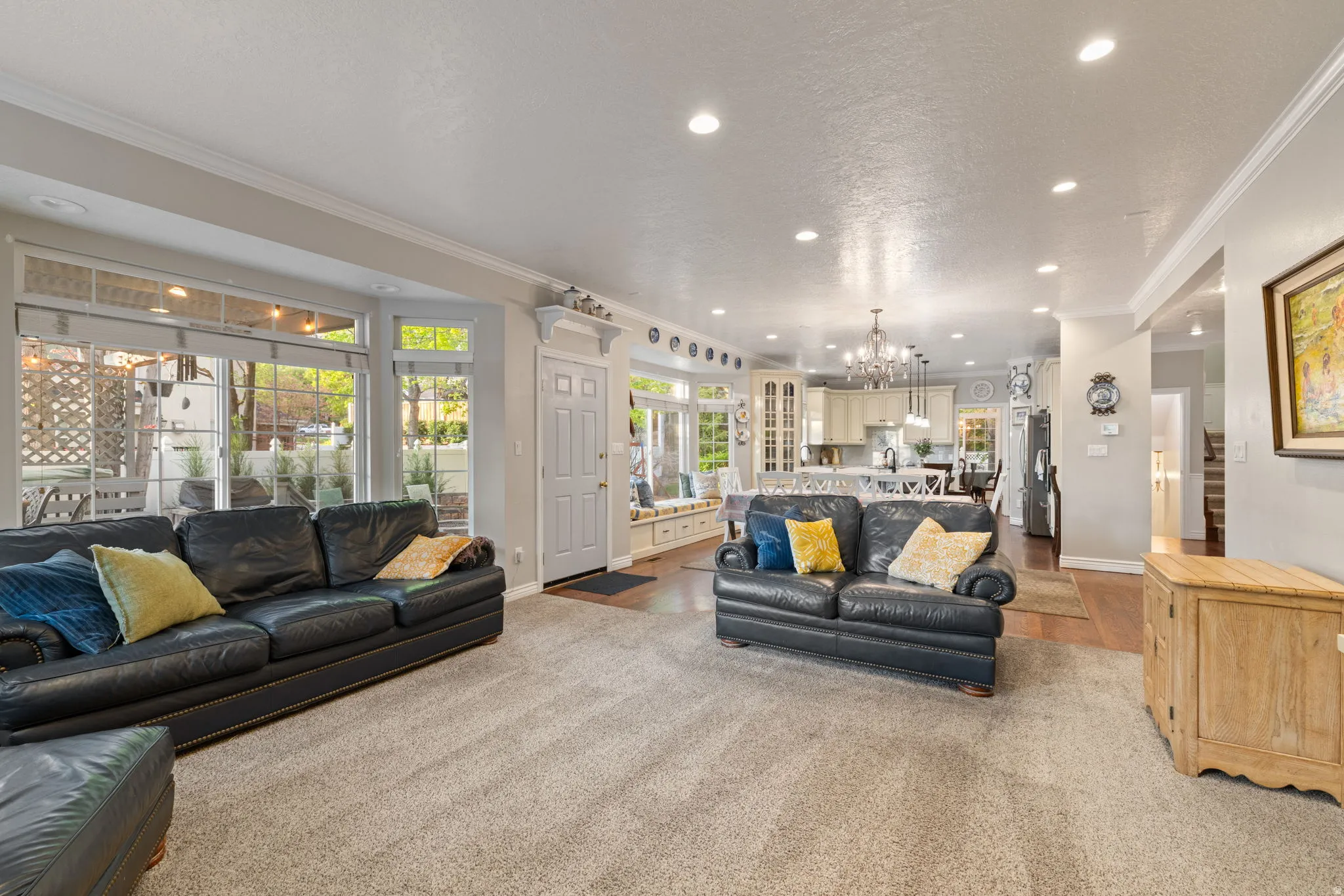 Open-concept living space featuring recessed lighting, crown molding, and a large bay window