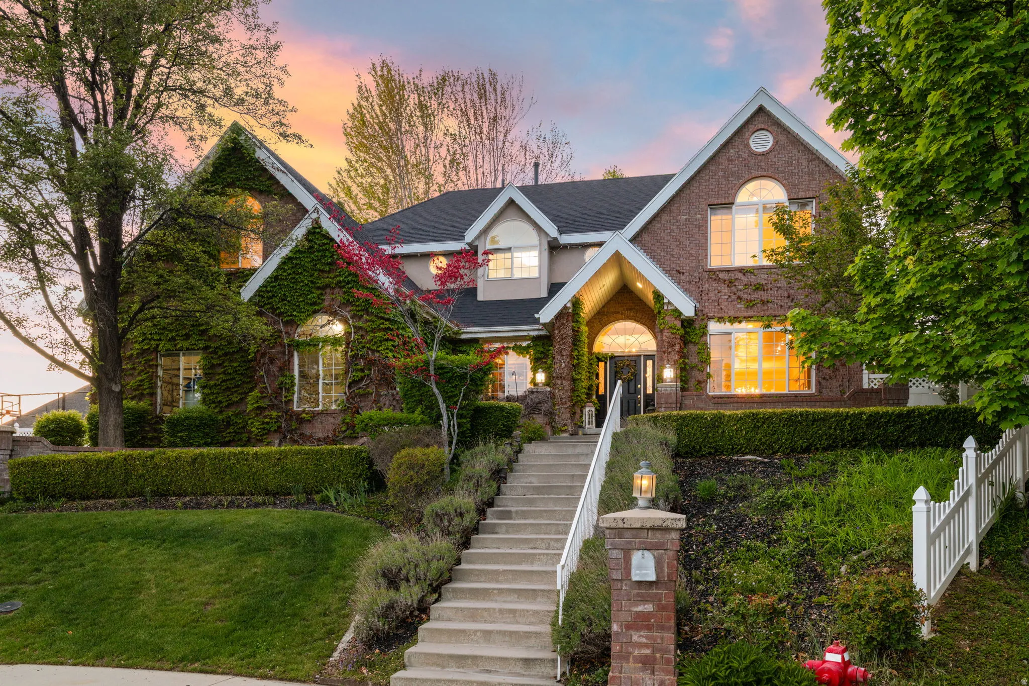 Brick exterior featuring mature climbing ivy, a multi-gabled roofline, and arched windows