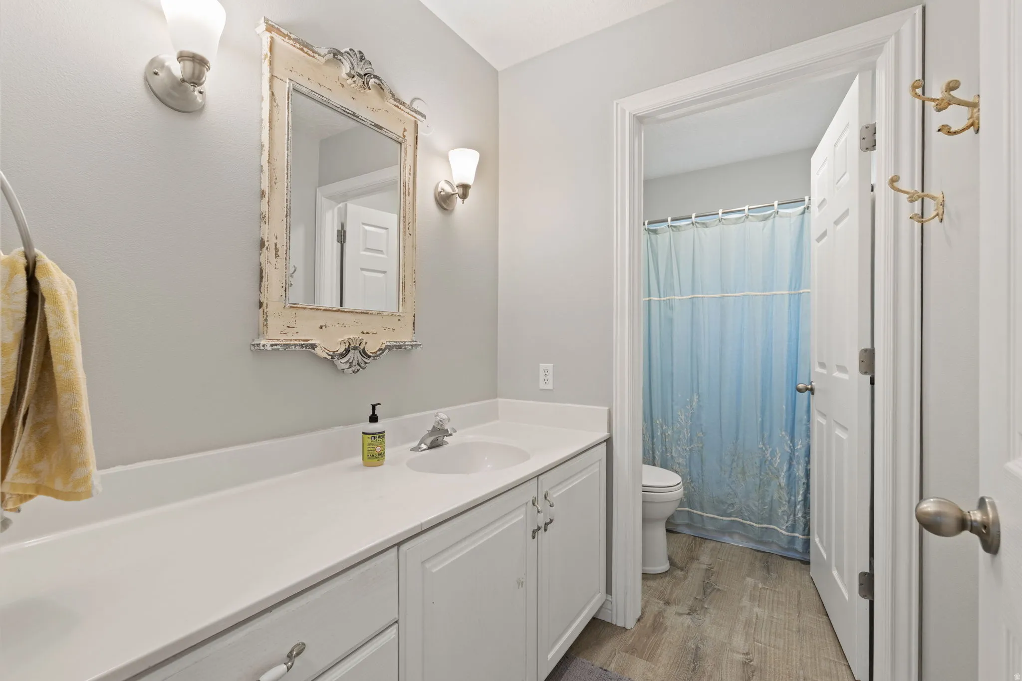 Bathroom vanity with white cabinetry, a light-colored countertop, and a single sink