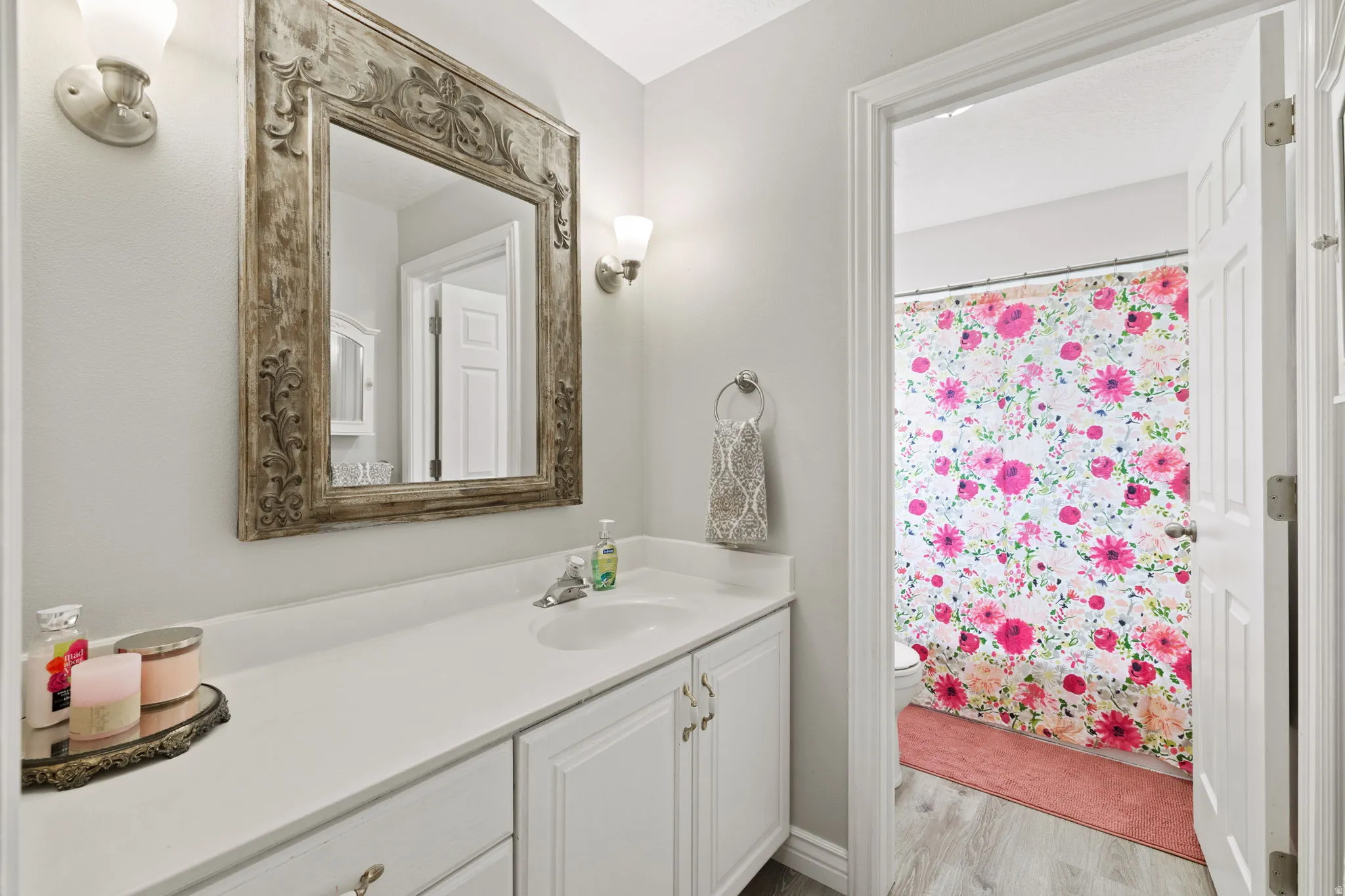 Bathroom vanity featuring white cabinetry, a single basin sink, and a white countertop
