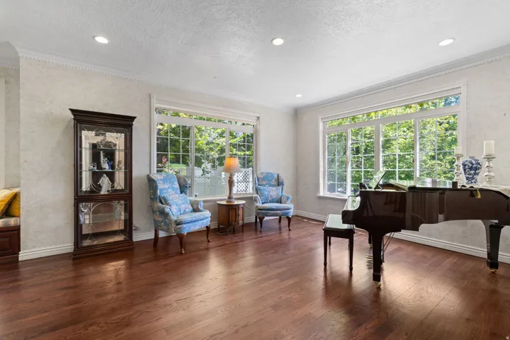 Spacious sitting oom featuring rich wood-finish flooring, recessed lighting, and large windows with transom details
