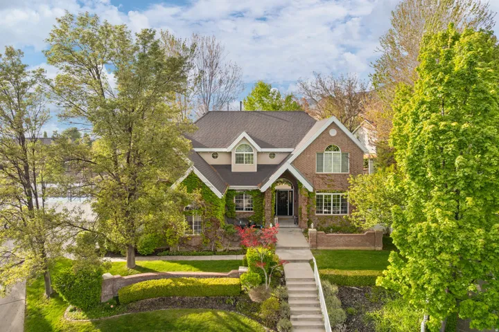 Brick and siding exterior featuring a multi-gable roofline, arched windows, and climbing ivy accents