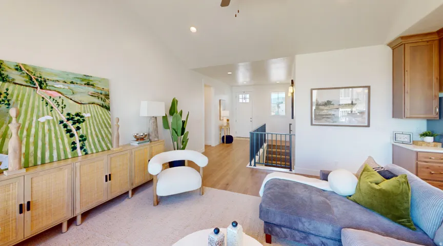 Open-concept living area featuring vaulted ceilings, recessed lighting, and wood-finish flooring