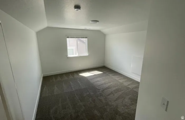 Carpeted room featuring a single window, white baseboards, and a neutral color palette