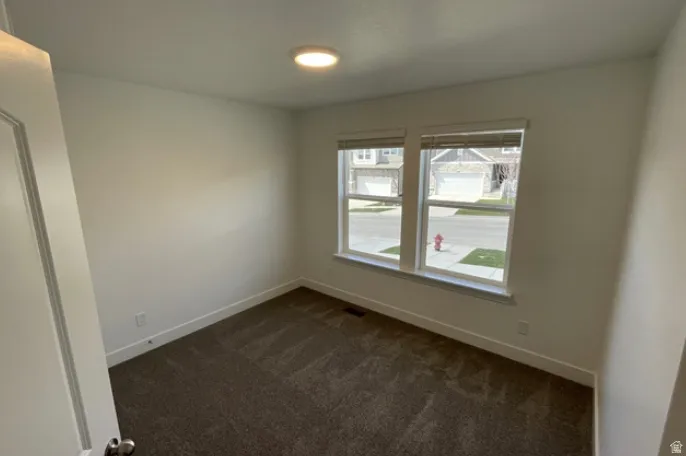 Neutral wall colors and dark carpeting define this interior room