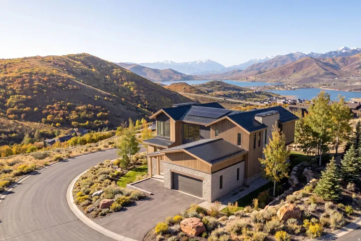 Modern mountain residence featuring a stone and wood siding exterior with a metal roof