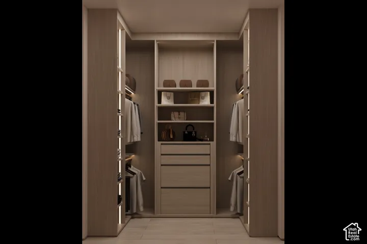 Custom closet system featuring light wood-finish cabinetry, integrated strip lighting, multiple shelving units, and built-in drawers