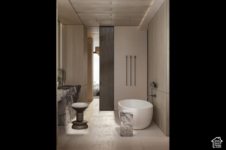 Modern bathroom featuring a freestanding soaking tub, floor-mounted tub filler, and integrated wall paneling