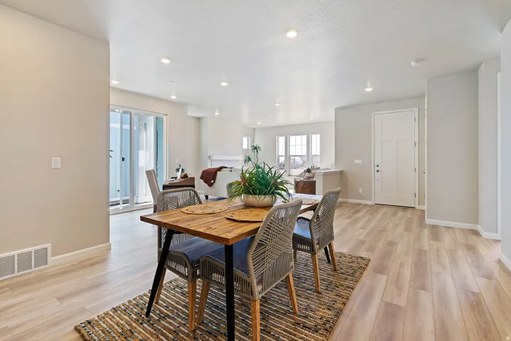 Open-concept dining area featuring wood-finish flooring, recessed lighting, and light-toned wall finishes