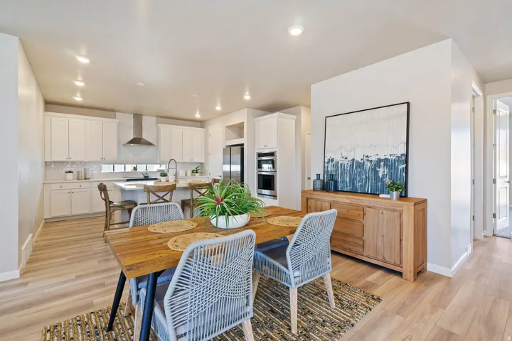 Open-concept dining area featuring wood-finish flooring, recessed lighting, and a neutral color palette