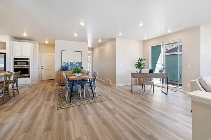 Open-concept living area featuring wood-finish flooring, recessed lighting, and light-toned walls