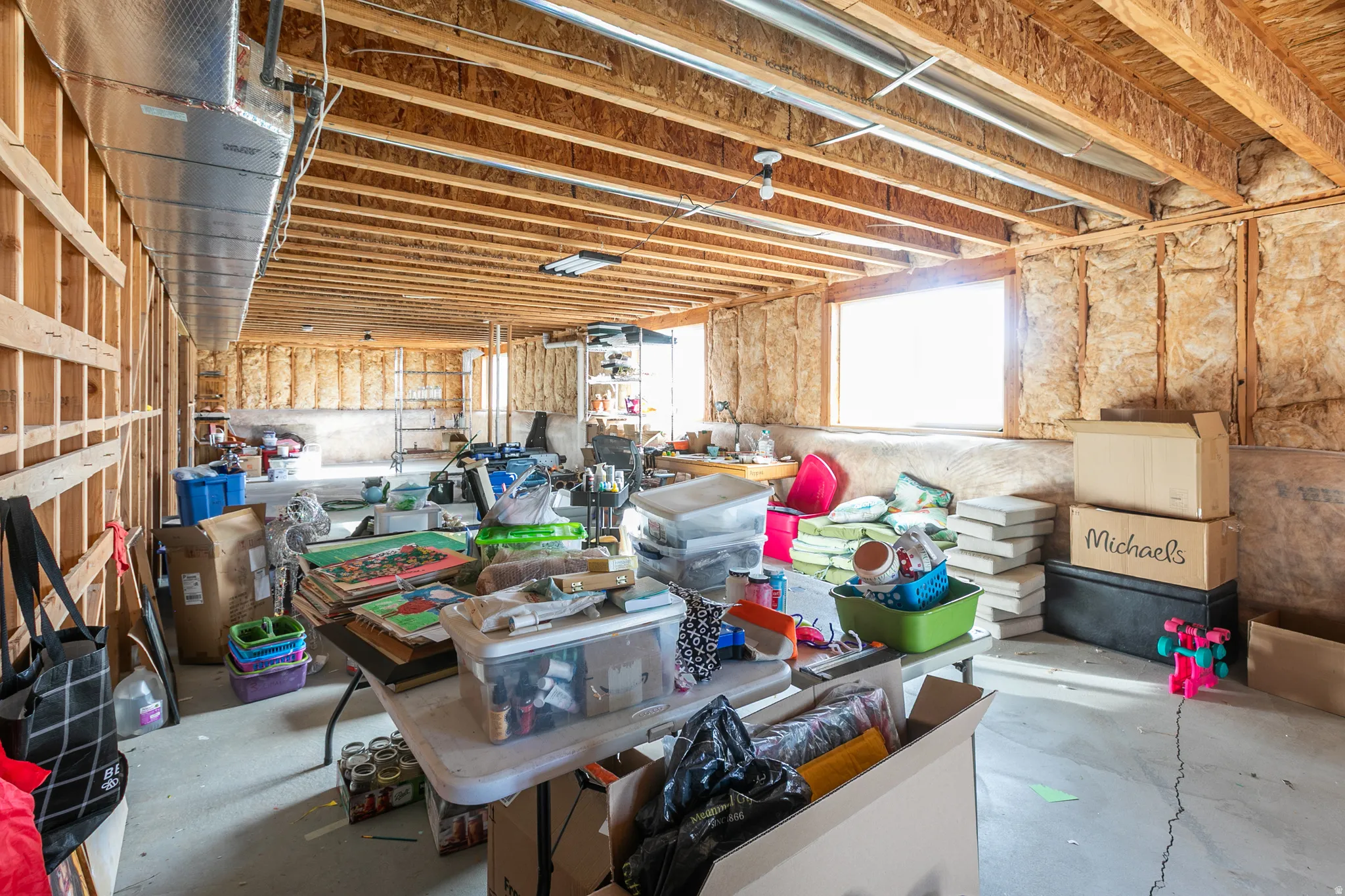 Unfinished basement with exposed wood framing, ceiling joists, and concrete flooring