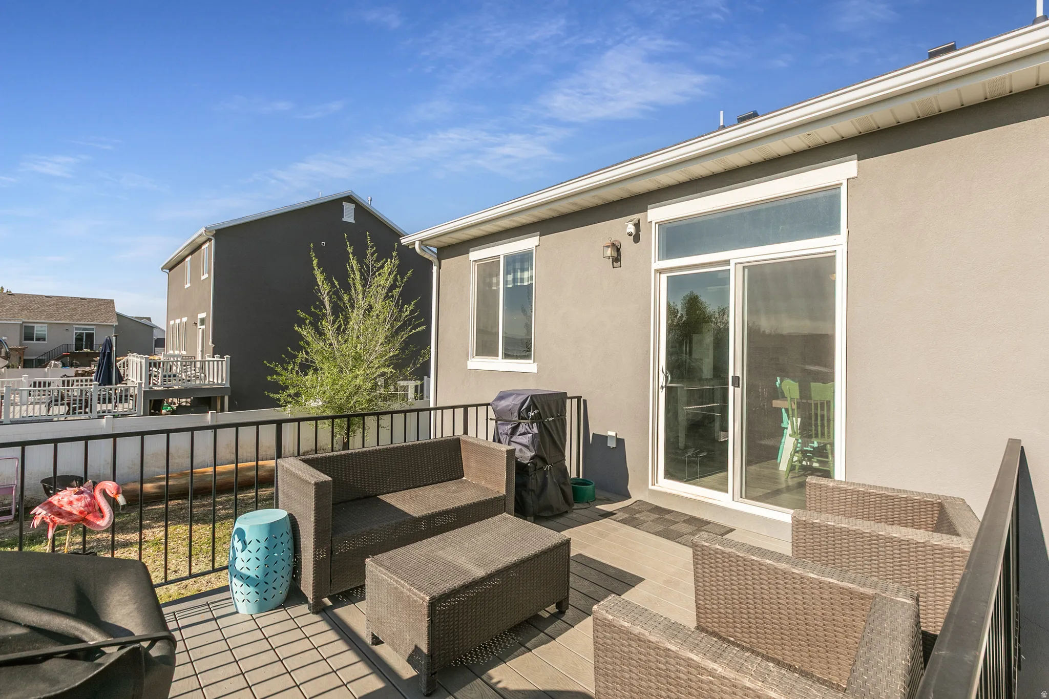 Outdoor deck featuring composite decking, black metal railings, and direct access to interior spaces via a sliding glass door