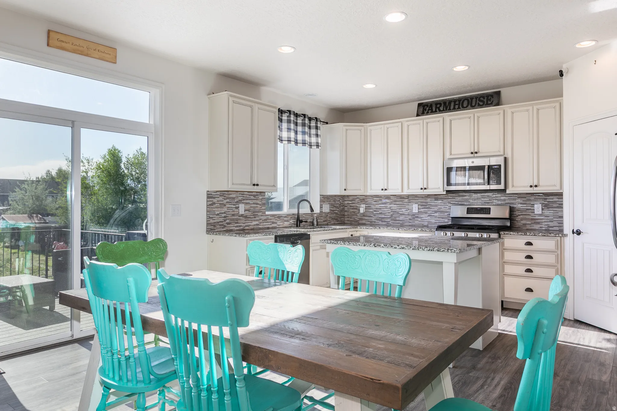 Modern kitchen featuring white cabinetry, granite countertops, and a full tile backsplash