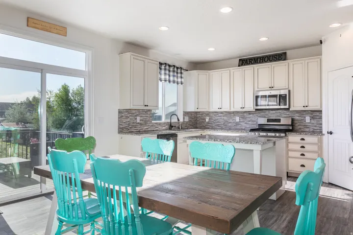 Modern kitchen featuring white cabinetry, granite countertops, and a full tile backsplash
