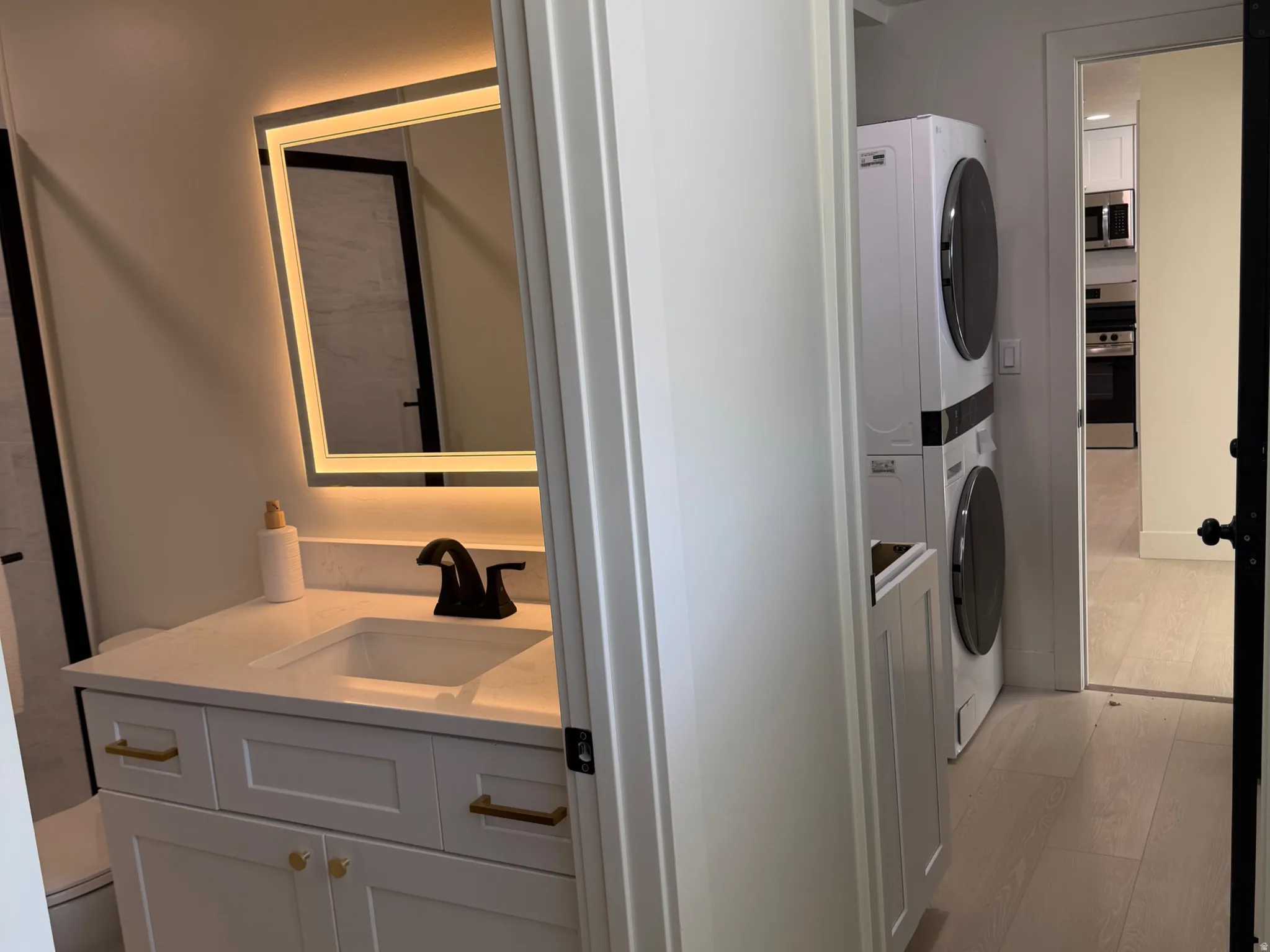 Bathroom featuring stacked washer / dryer and vanity