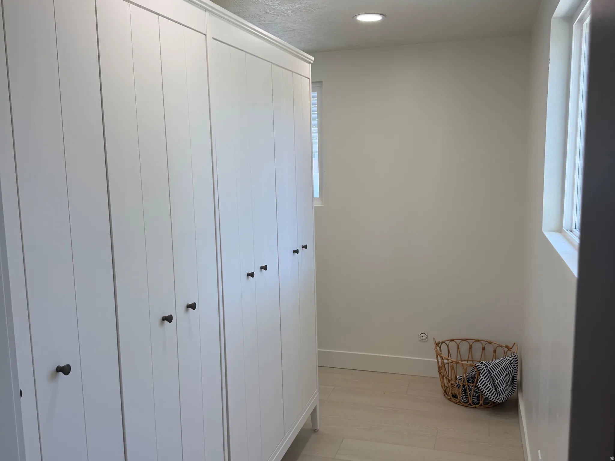 Corridor featuring recessed lighting, a textured ceiling, and light wood-style flooring