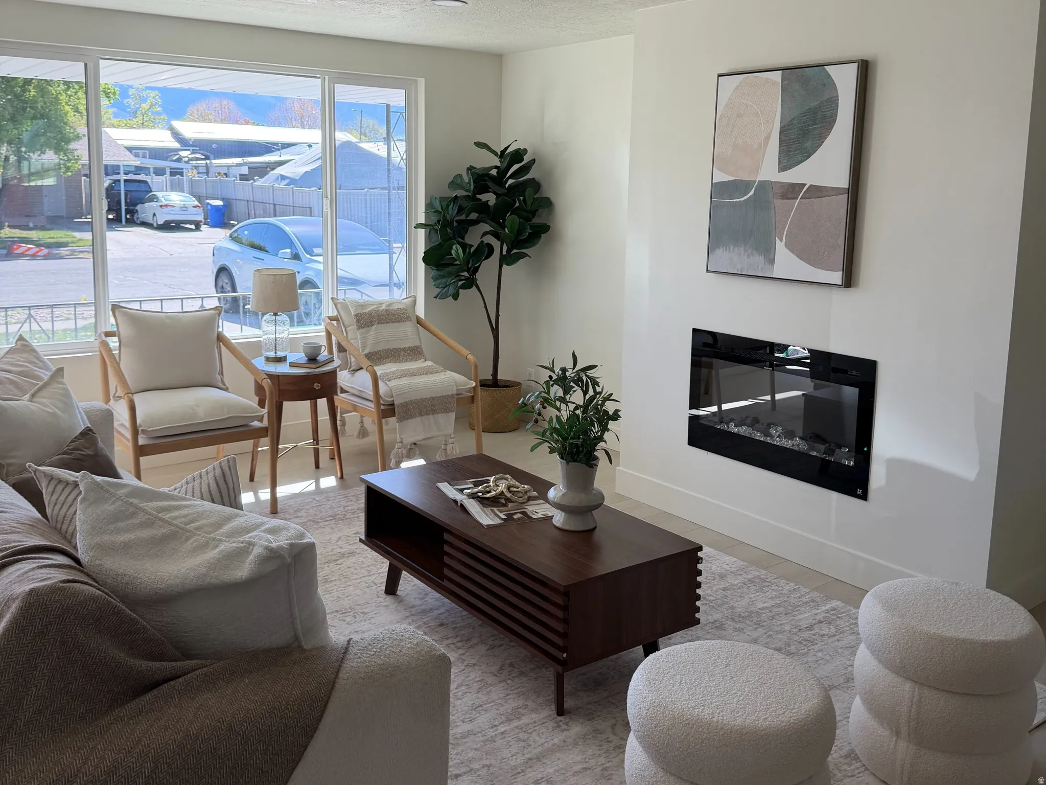 Living room featuring a glass covered fireplace and a textured ceiling