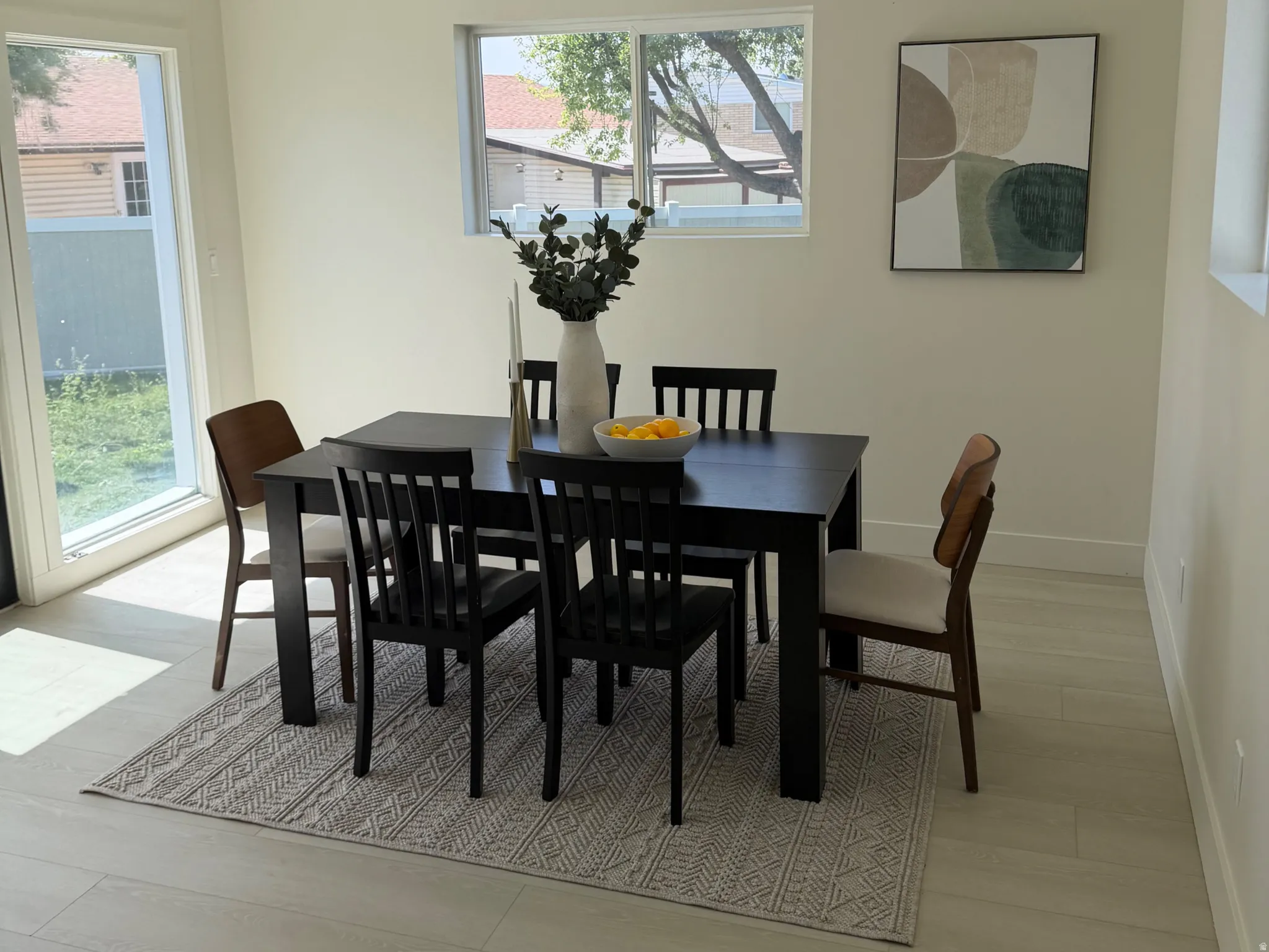 Dining room with light wood-type flooring, plenty of natural light, and a textured ceiling
