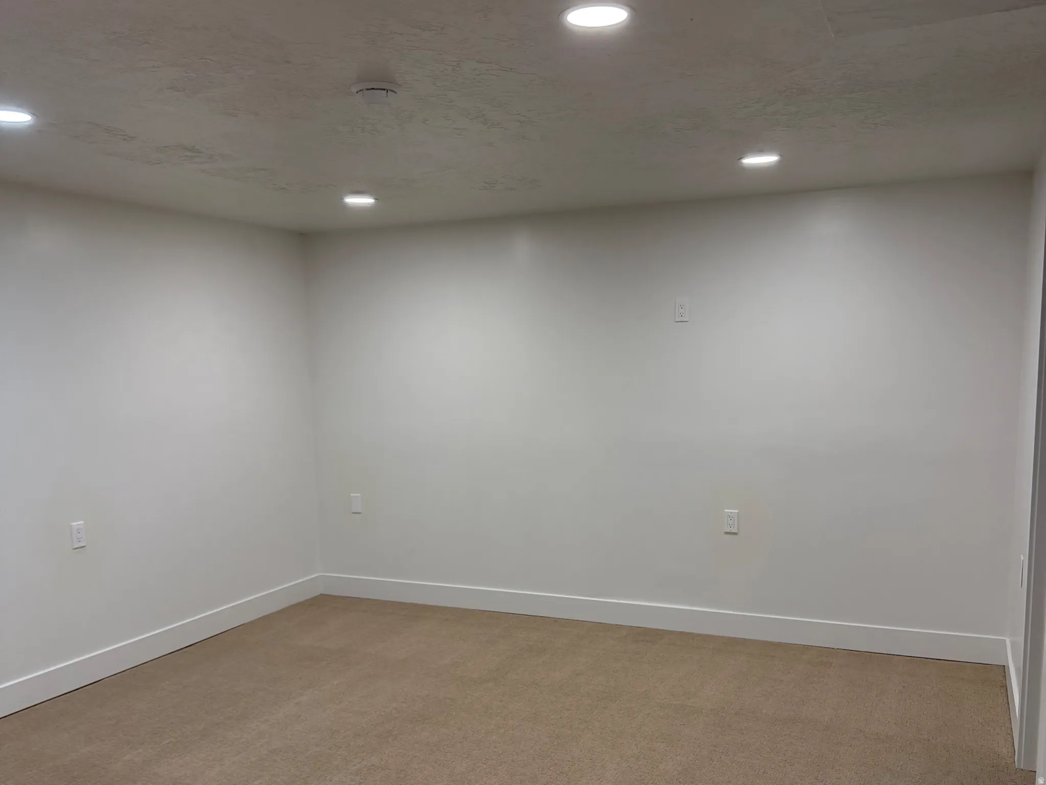 Spare room featuring light colored carpet and recessed lighting