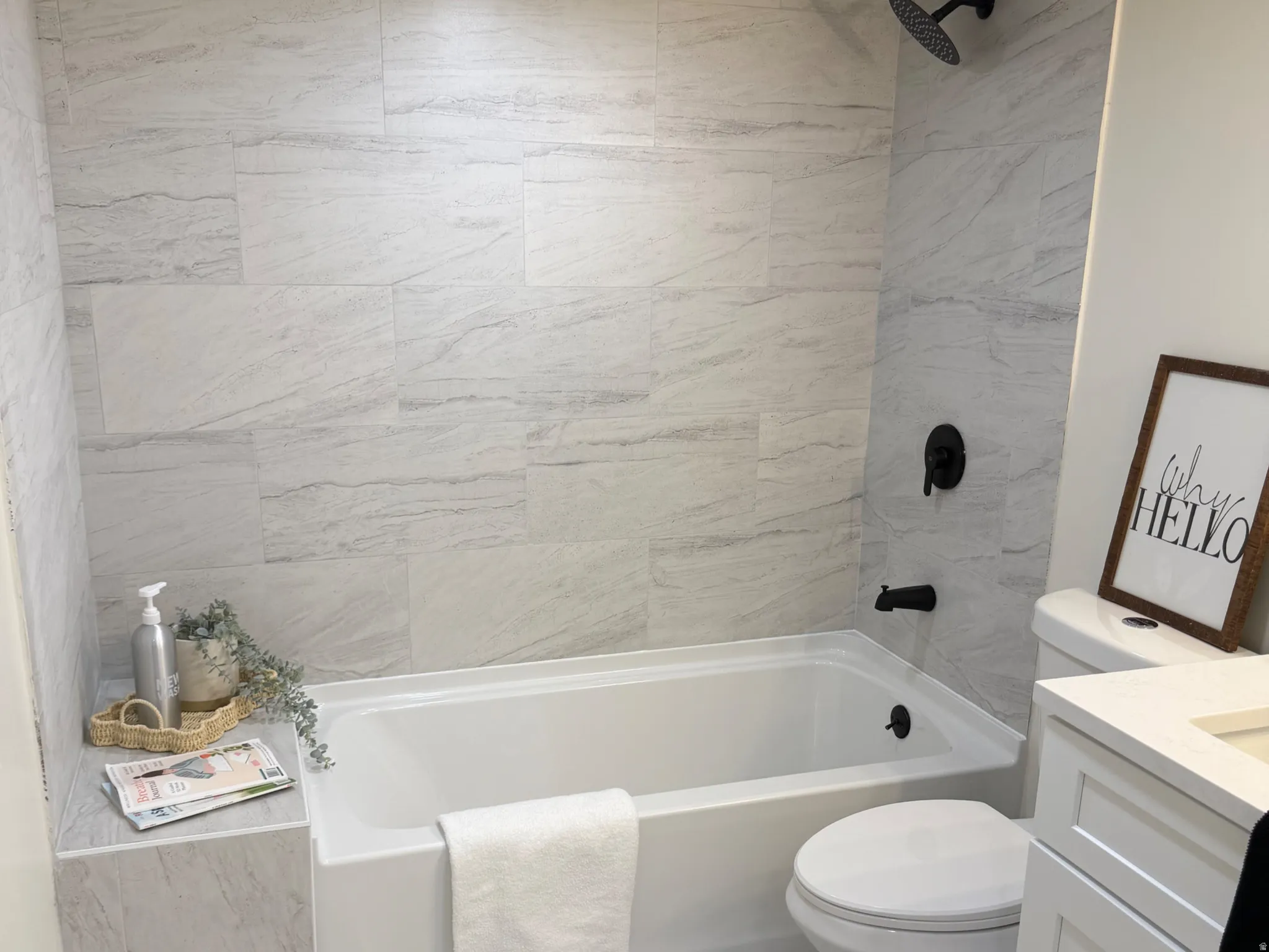 Bathroom with vanity, a textured ceiling, and washtub / shower combination