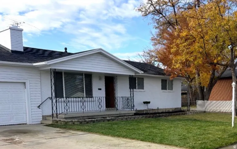 Ranch-style home with covered porch, a garage, and driveway