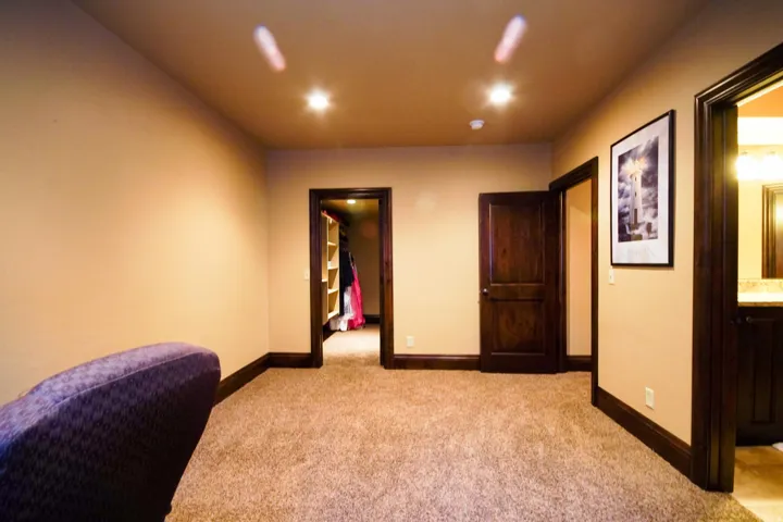 Carpeted room featuring recessed lighting, dark wood-finish doors, and matching baseboards