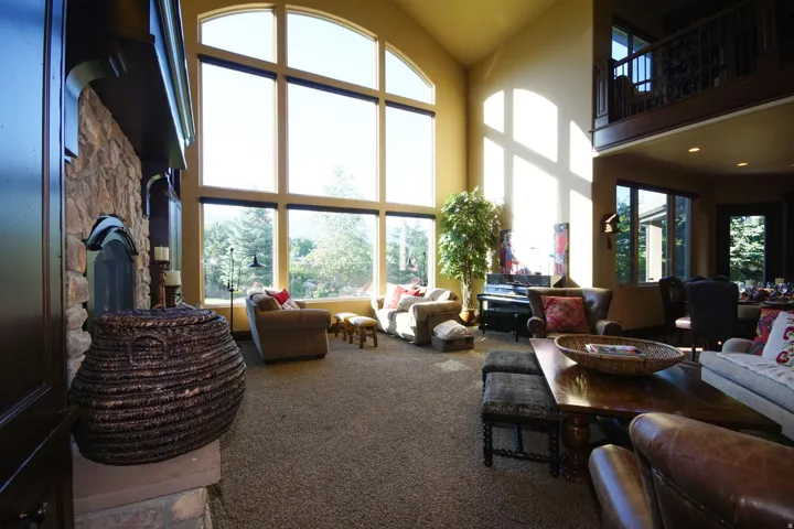 Grand living area featuring a two-story arched window wall
