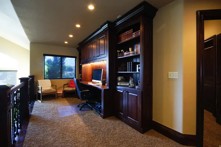 Built-in dark wood cabinetry and shelving unit with integrated desk space
