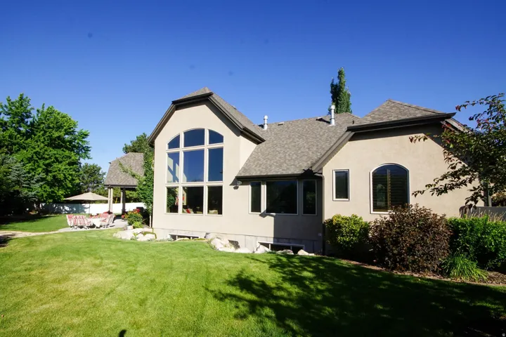 Expansive stucco exterior featuring a prominent two-story arched window