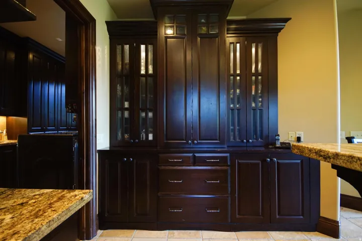 Custom built-in cabinetry with dark wood finish, glass-front upper cabinets, and multiple storage drawers