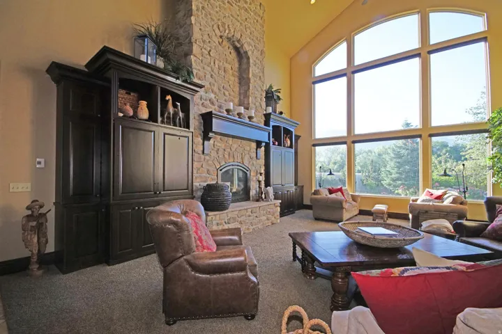 Vaulted living space featuring a floor-to-ceiling stone fireplace