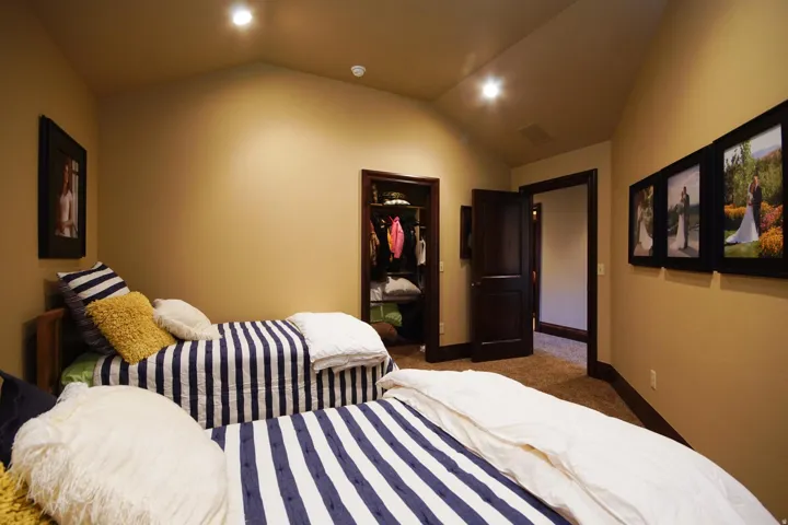Vaulted ceiling bedroom with recessed lighting, dark wood trim, carpet flooring, a built-in closet, and a dark wood panel door