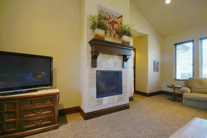 Corner fireplace featuring a tile surround, dark wood mantel, and hearth