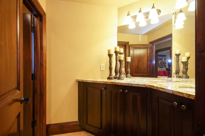 Curved vanity featuring a speckled countertop and dark wood-finish cabinetry