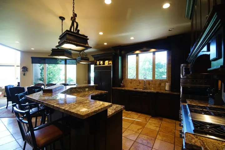 Kitchen featuring dark wood cabinetry, granite countertops, and tile flooring
