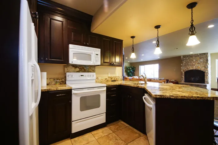 Kitchen featuring dark wood cabinetry, light-toned countertops, and coordinating tile flooring
