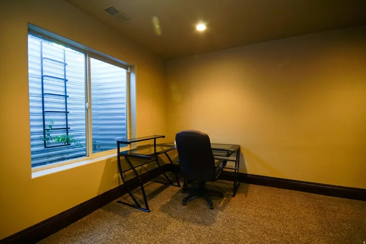 Room with neutral-toned walls and speckled carpeting