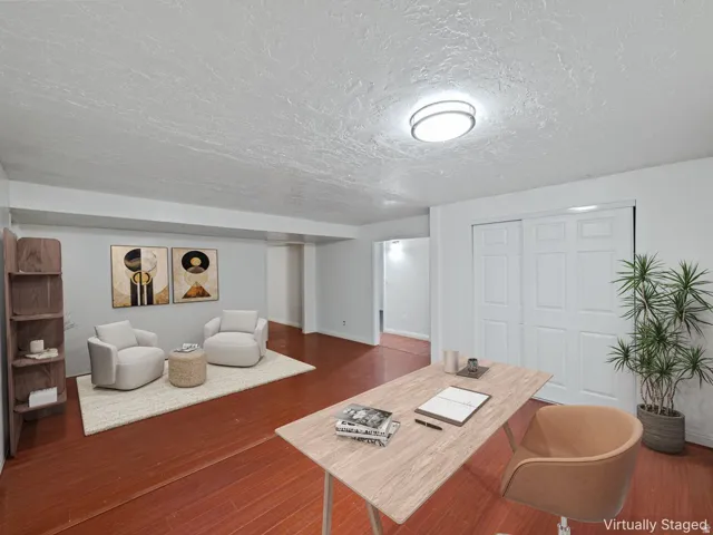 Spacious room featuring rich wood-finish flooring and a neutral color palette