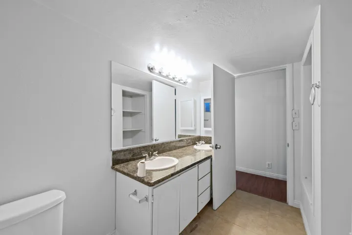 Double vanity with integrated sinks and a stone-finish countertop