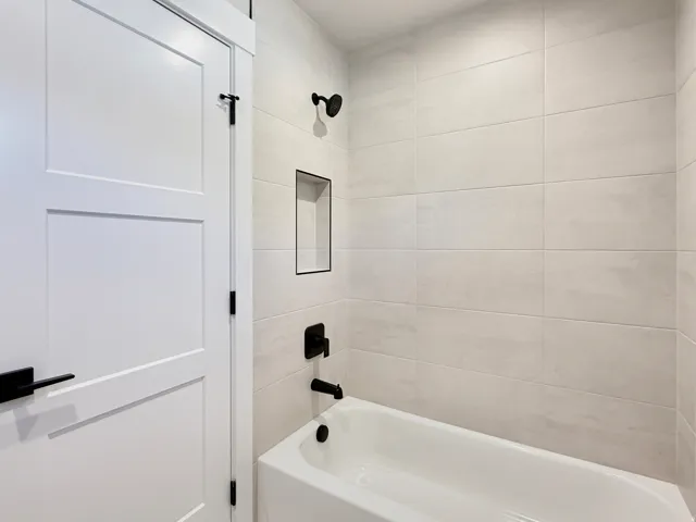 White tub and shower combination with matte black fixtures