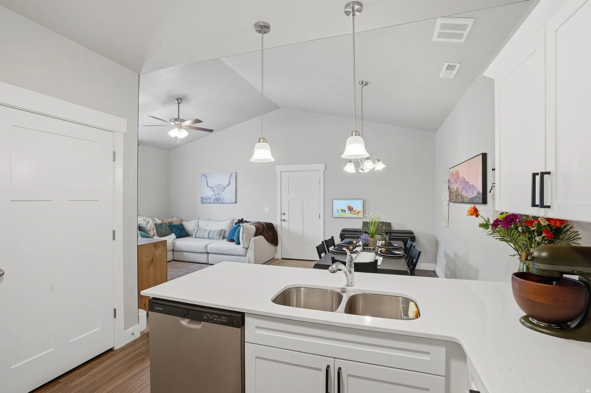 Modern kitchen featuring white cabinetry, stainless steel dishwasher, and a double basin sink with a chrome faucet